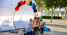 A family posing for a photo with a colorful backdrop